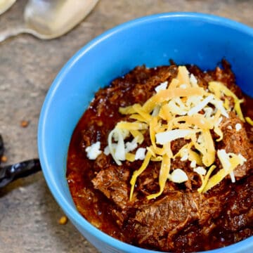 Vibrant red chili Colorado in a blue bowl.