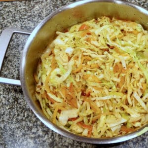 A silver pot filled with Apple and Onion Braised Cabbage with Bacon.