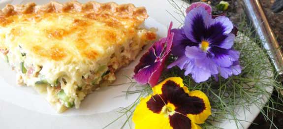 Bacon and Zucchini Quiche with beautiful poppies on a place.