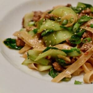 Chinese Style Noodles with Ground Lamb and Bok Choy in a white bowl.