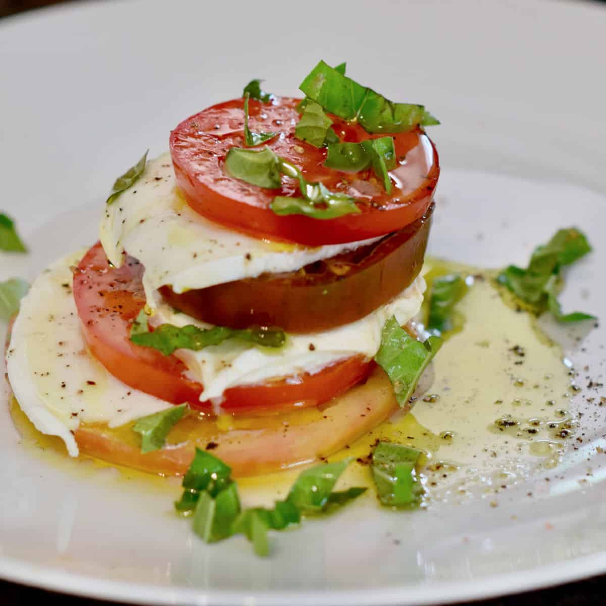 A classic stack for a caprese salad. Tomato and Mozzarella cheese with basil.