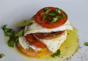 Heirloom tomatoes, mozzarella, olive oil, and fresh basil leaves make this simple salad delicous.
