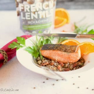 Crispy Skin Salmon with Lentils and Bacon in a white bowl with a bag of lentils behind it.