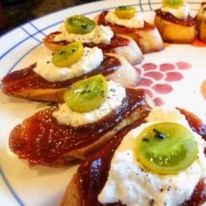 A colorful plate of crostini with tomato jam and homemade ricotta cheese.