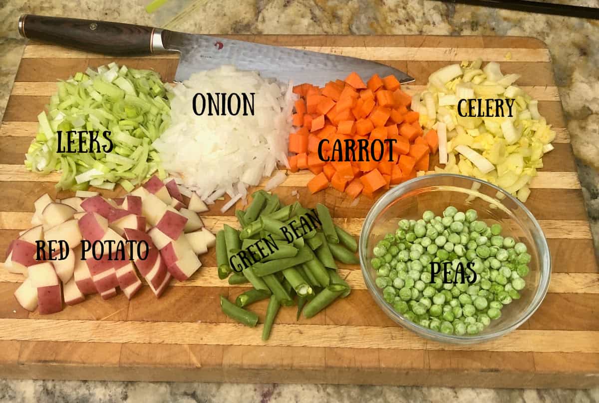 A cutting board with the pot pie ingredients identified on it.