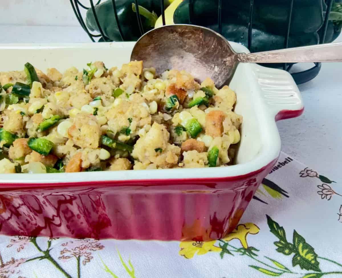 Summertime Cornbread Stuffing in a red baking dish being served.