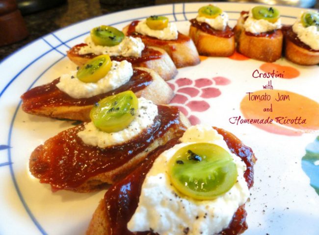 Crostini with Tomato Jam and Ricotta on a plate with colorful tomato toppings.