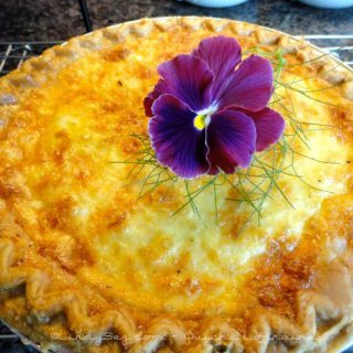 Quiche Lorraine with a purple pansy on top.