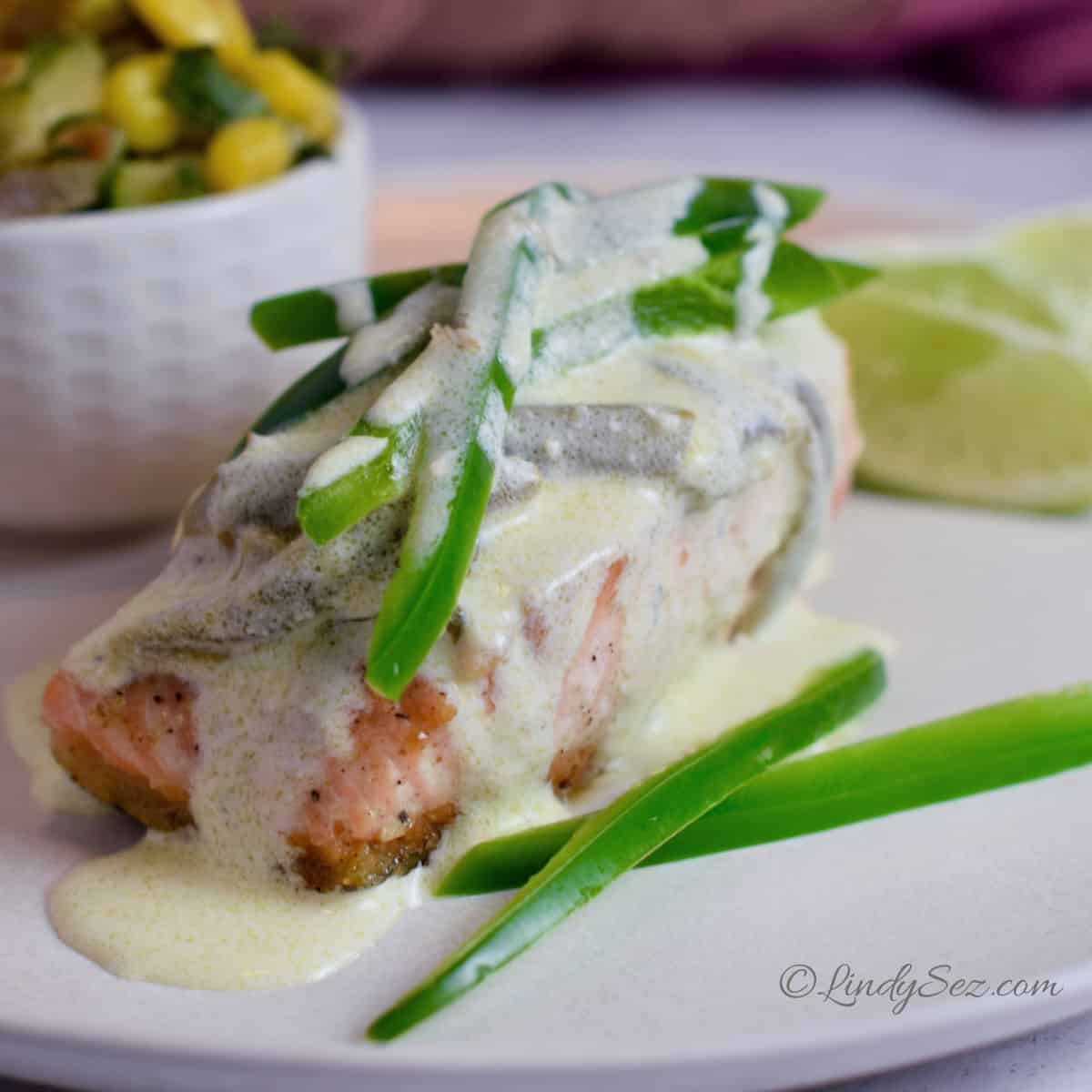 a close up image of salmon with jalapeno cream sauce.