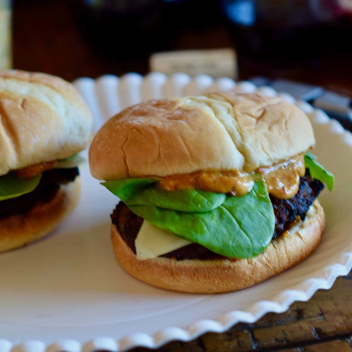 Caramelized Bacon Onion Burger being served on a white paper plate.