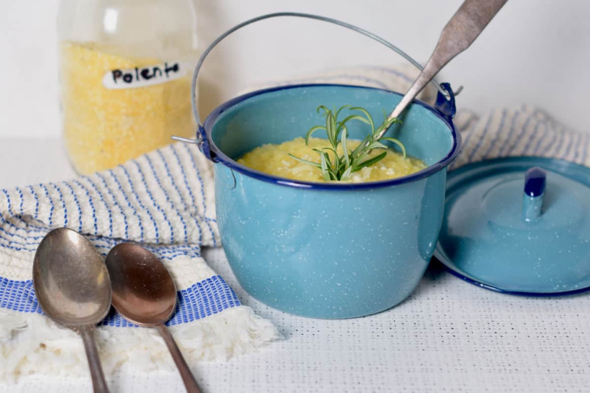 Polenta in a blue pot with spoons.