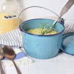 A blue pot with a jar of polenta on a striped towel showing how to bake polenta.