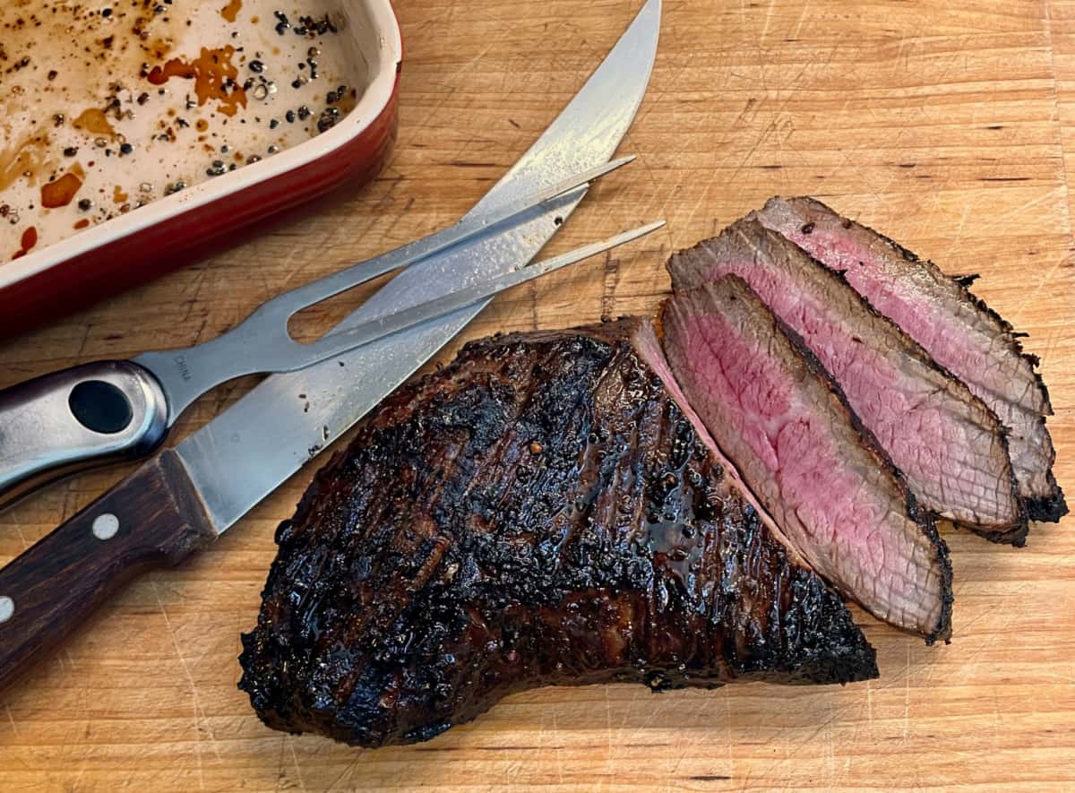 A perfect medium rare tri-tip steak on a cutting board.