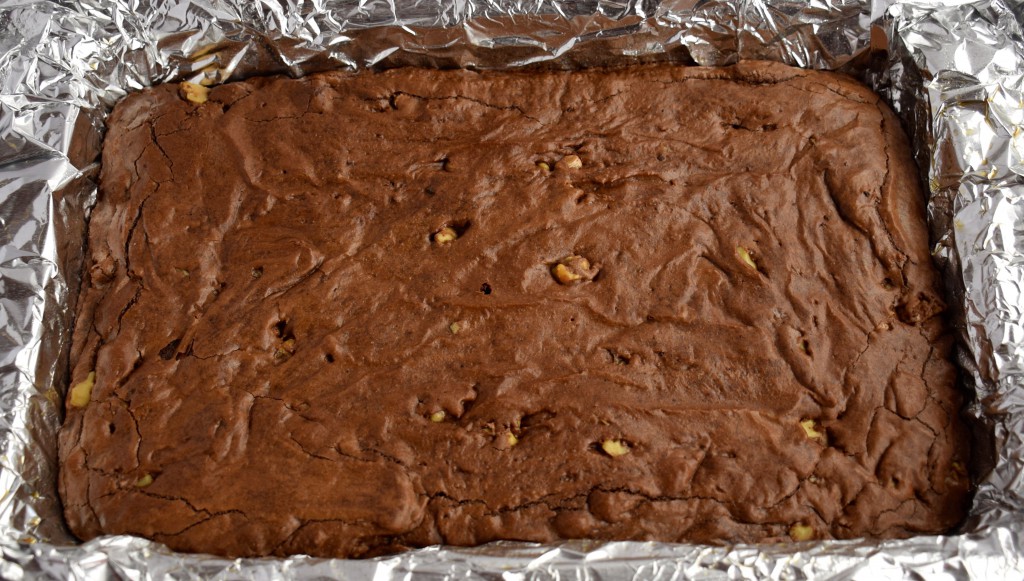 Fudgy chocolate brownies in a sheet pan with foil liner.