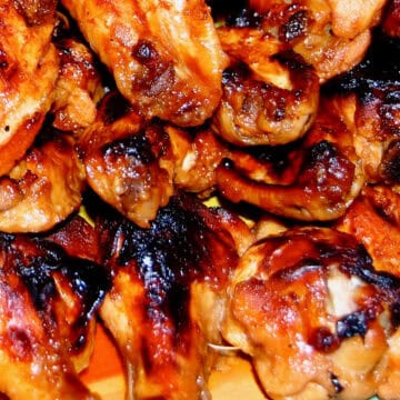 An image of gooey chicken wings with a lot of browned goodness.