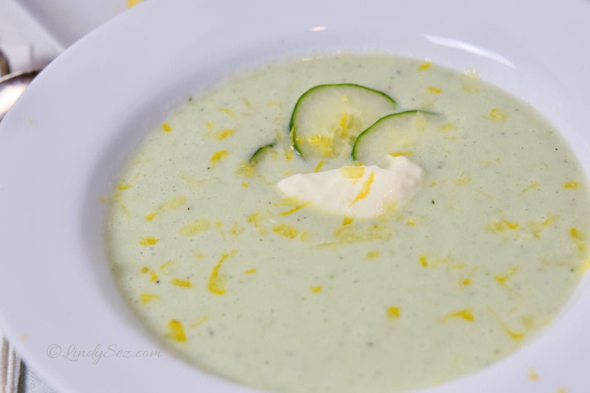 A bowl of cucumber soup, chilled, with a dollop of yogurt and fresh slices of cucumber.