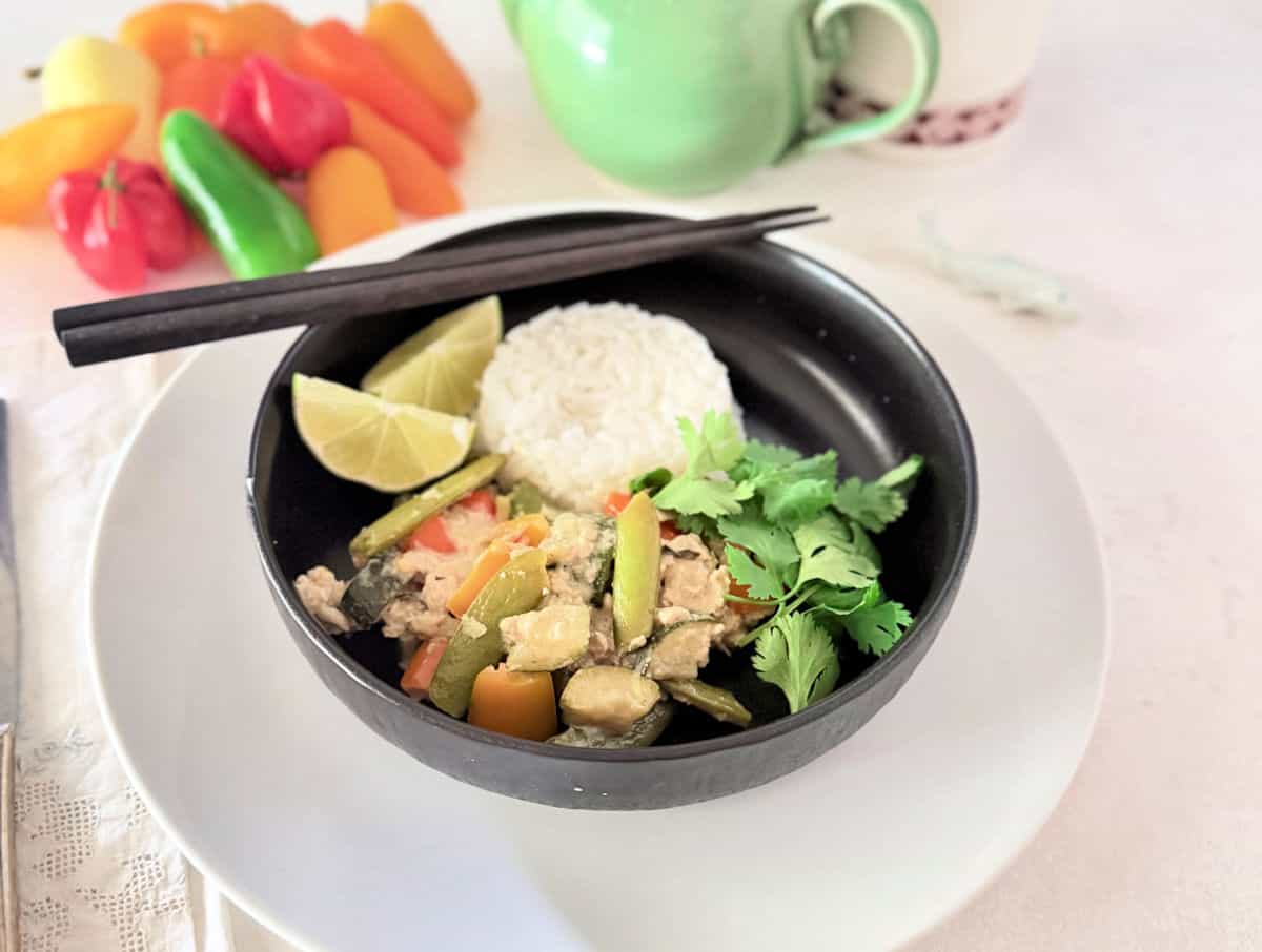 Thai-Minched-Chicken-Stir-Fry in a balck bowl with chopsticks.