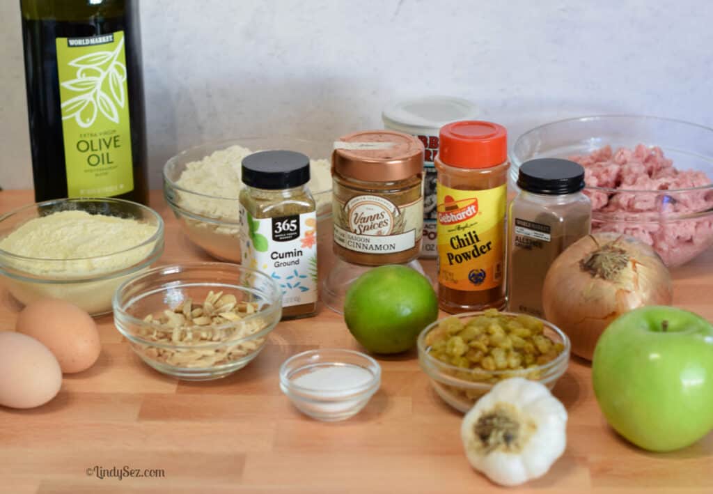 The ingredients needed for Pork Picadillo Empanadas on a board. 
