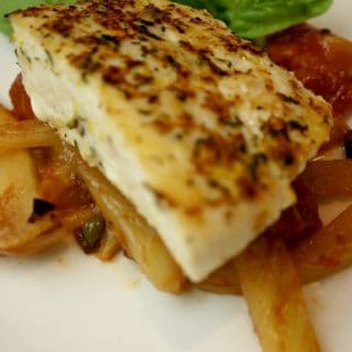 A plate with a piece of halibut on top of fresh tomato fennel sauce.