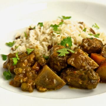 A bowl of Lamb Vindaloo served with a side of Basmati Rice.