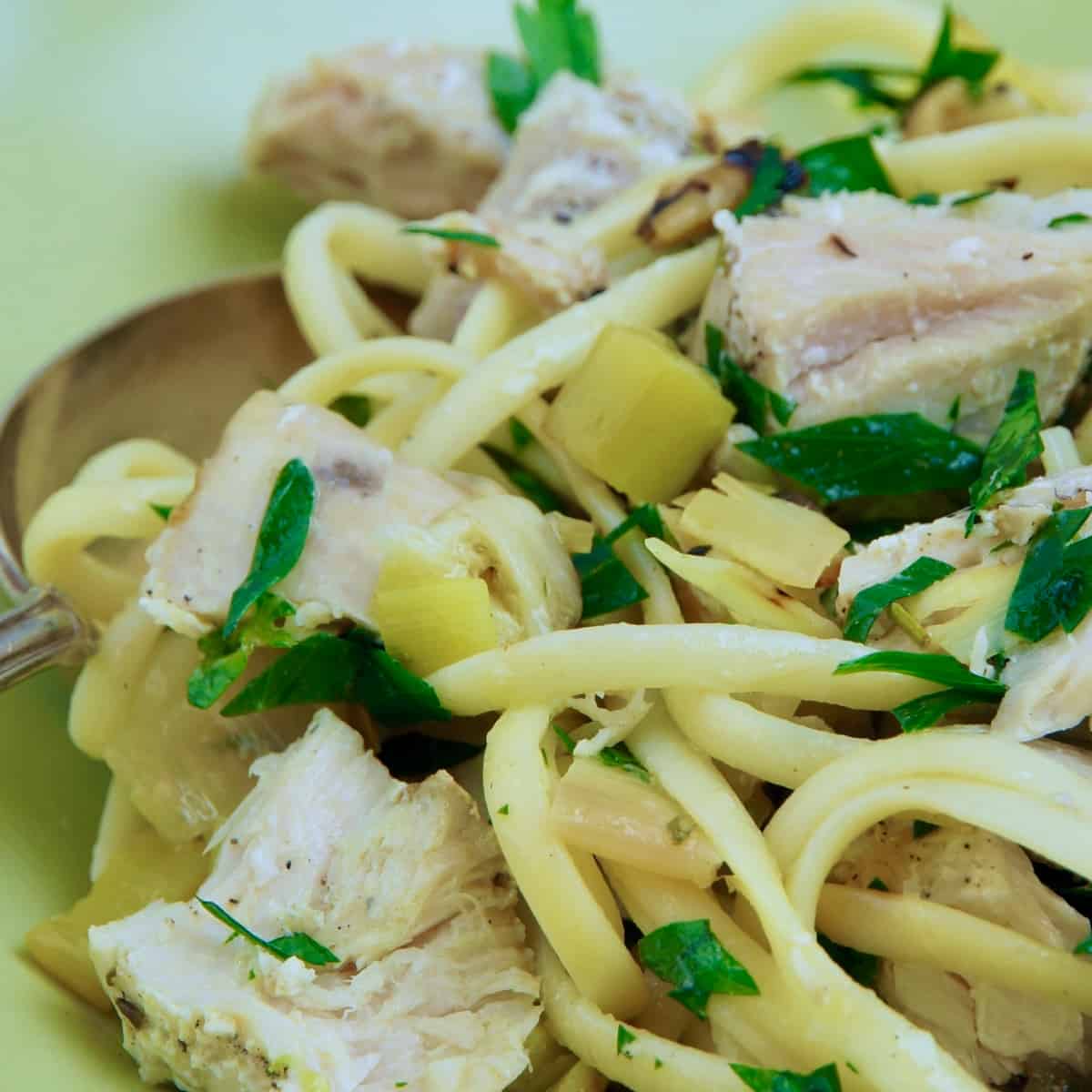 A green bowl holds some linguine with grilled tuna.