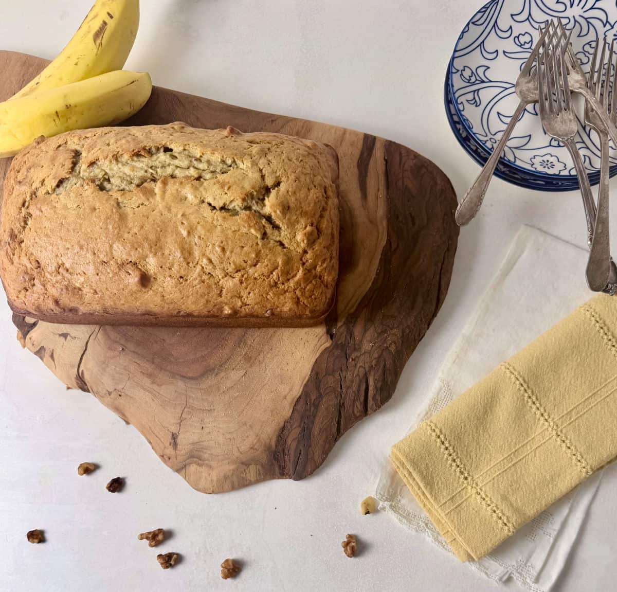 A freshly baked loaf of Lindy's Old-Fashioned Banana Bread with Buttermilk on a cut board ready for serving.
