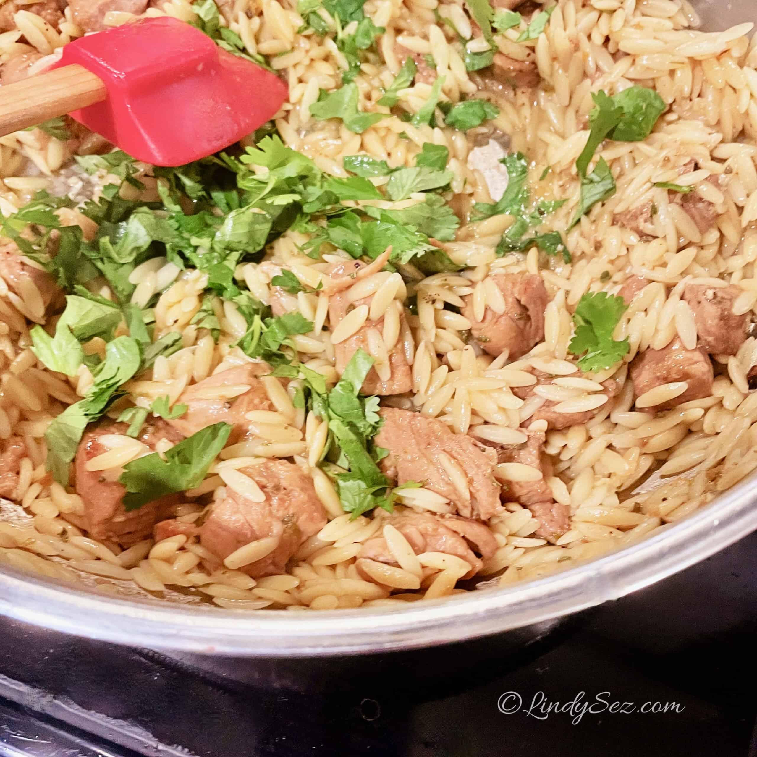 Tequila Sunrise pork with orzo in a white bowl.