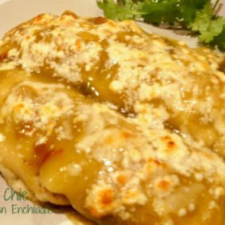 Hatch Green Chile Chicken Enchilada on a plate covered in melted cheese.
