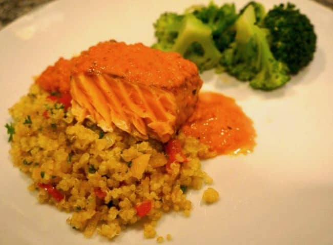 A plate with Quinoa, Salmon, Red Pepper Sauce, and broccoli.