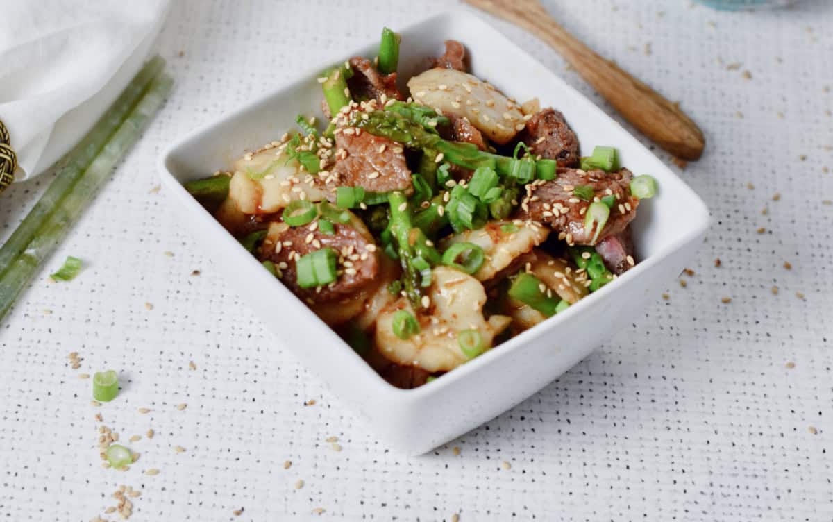Beef Scallop stir-fry in a white square bowl.