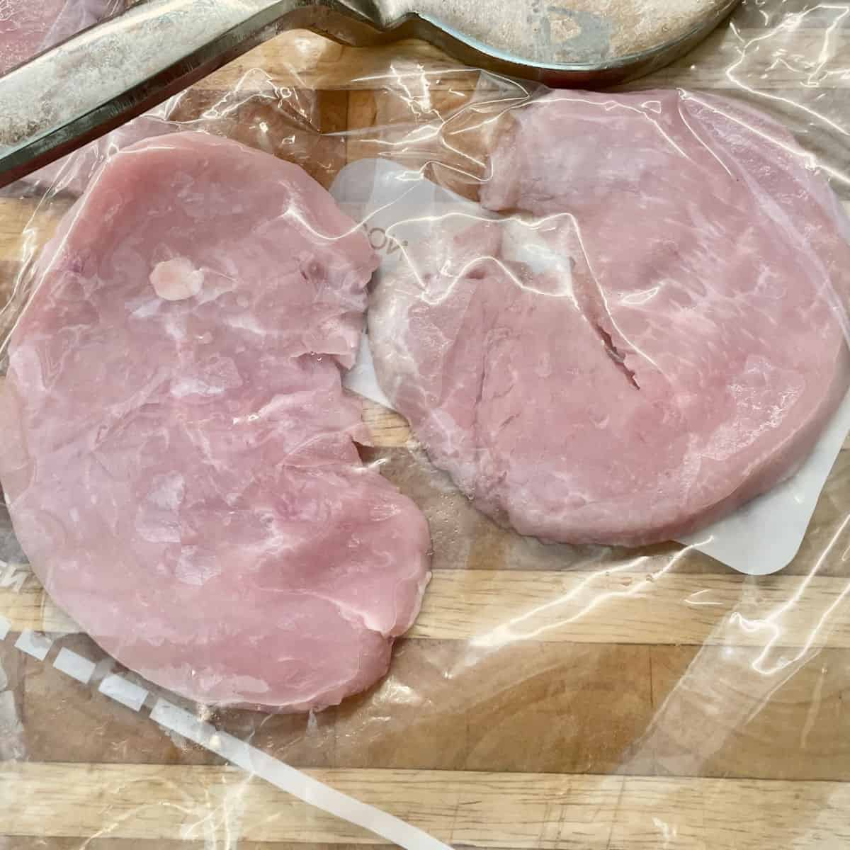 Two turkey cutlets in a bag ready to be pounded.