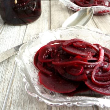 An antique glass dish holds colorful pickled beets.