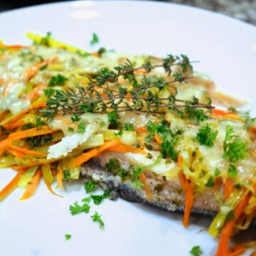 A plate of garnished Easy to make Riesling Poached Trout.