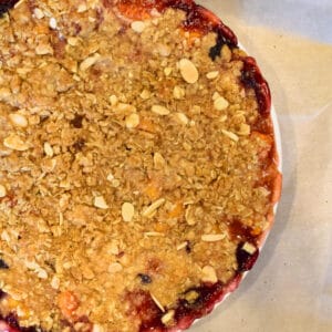 A Easy Fresh Peach Blueberry Crumble on parchment paper.