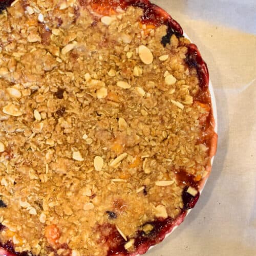 A Easy Fresh Peach Blueberry Crumble on parchment paper.
