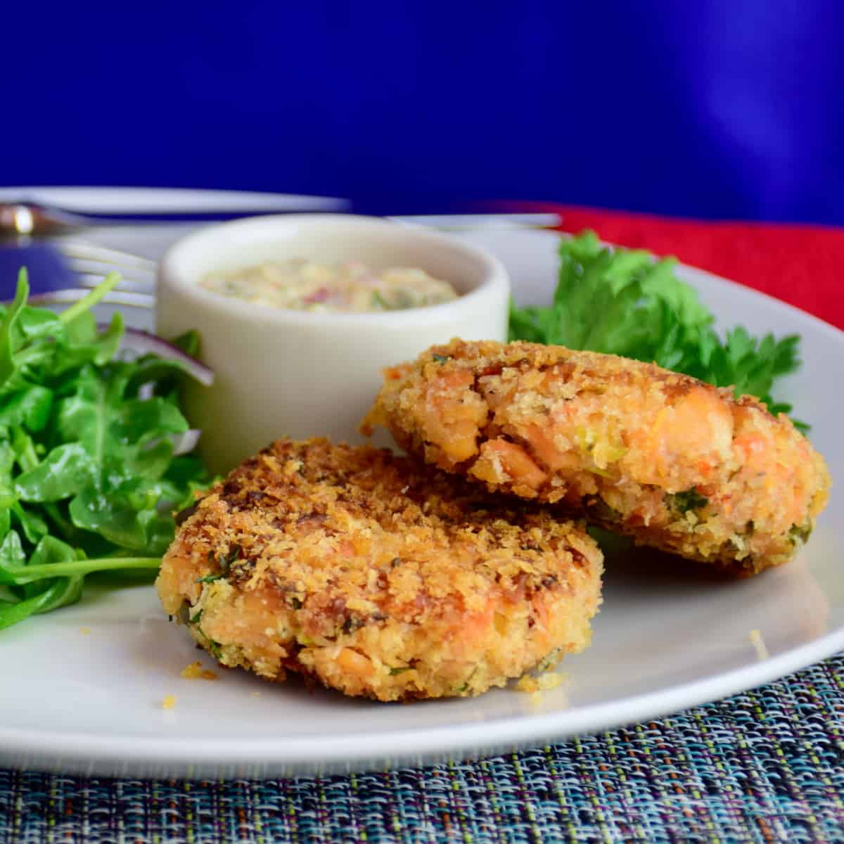 Salmon Cakes with Spicy Remoulade on a plate with green salad .