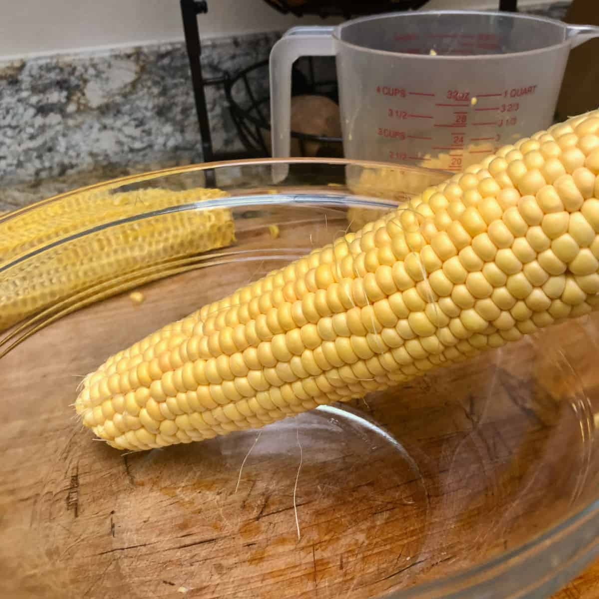 An ear of corn in a glass bowl.