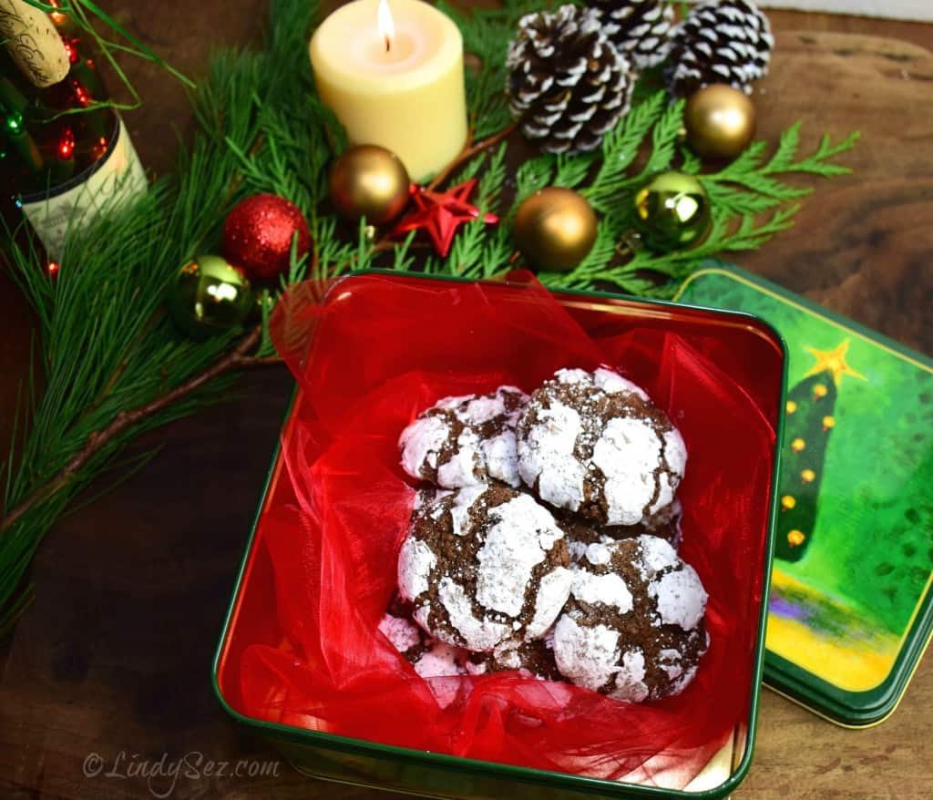 Chocolate Crinkle Cookies on a red plate in a festive holiday scene.