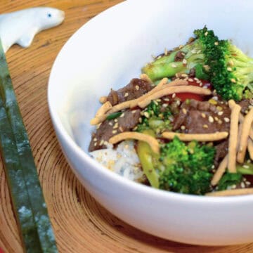 Beef Broccoli Stir Fry in a bowl with a pair of jade chop sticks.