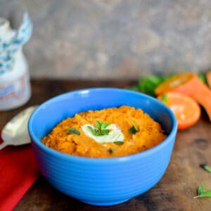 Tangerine Chipotle Sweet Potato Mash in a blue bowl with tangerines.