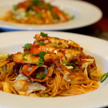 A white bowl filled with Spicy Crab Noodles.