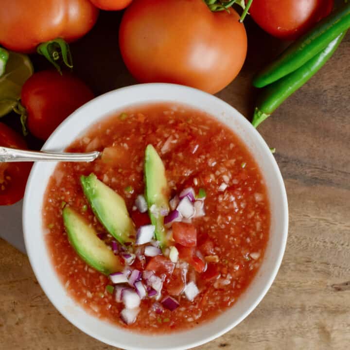 Fresh Gazpacho in a white bowl with garnishments.