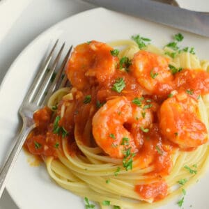 Shrimp with Fresh Fra Diavolo Sauce on a white plate with a fork.