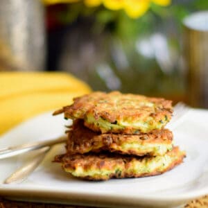 A stack of Zucchini Latke with Fresh Herbs and Feta on a plate with a yellow napkin.