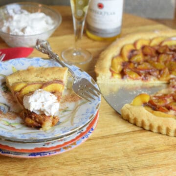 French Plum Tart on a stack of plates.