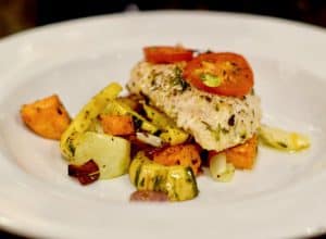 A plate of oven poached chicken with veggies