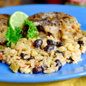 Black beans, corn, rice, and chicken on a blue plate.
