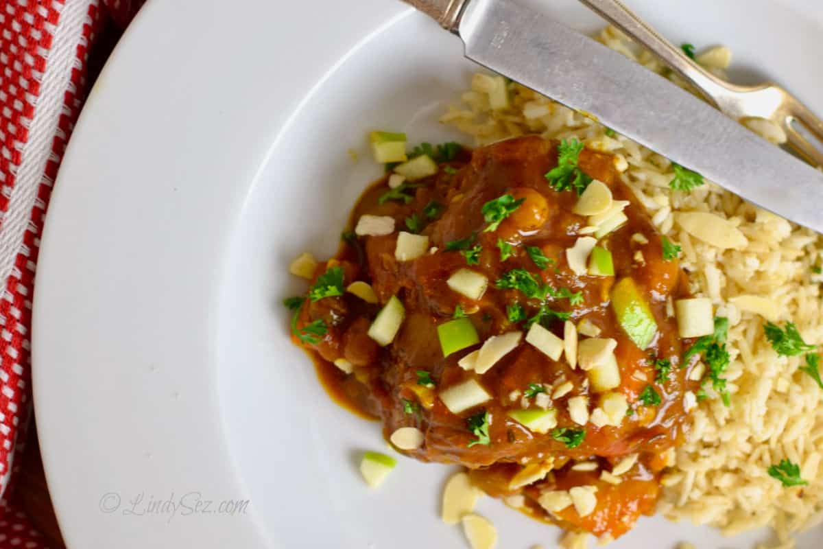 Overhead view of country chicken on a plate with rice.