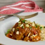 Richly spiced nstant Pot Country Captain Chicken in a large white bowl with a red and white cloth.