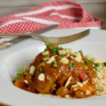 Richly spiced nstant Pot Country Captain Chicken in a large white bowl with a red and white cloth.